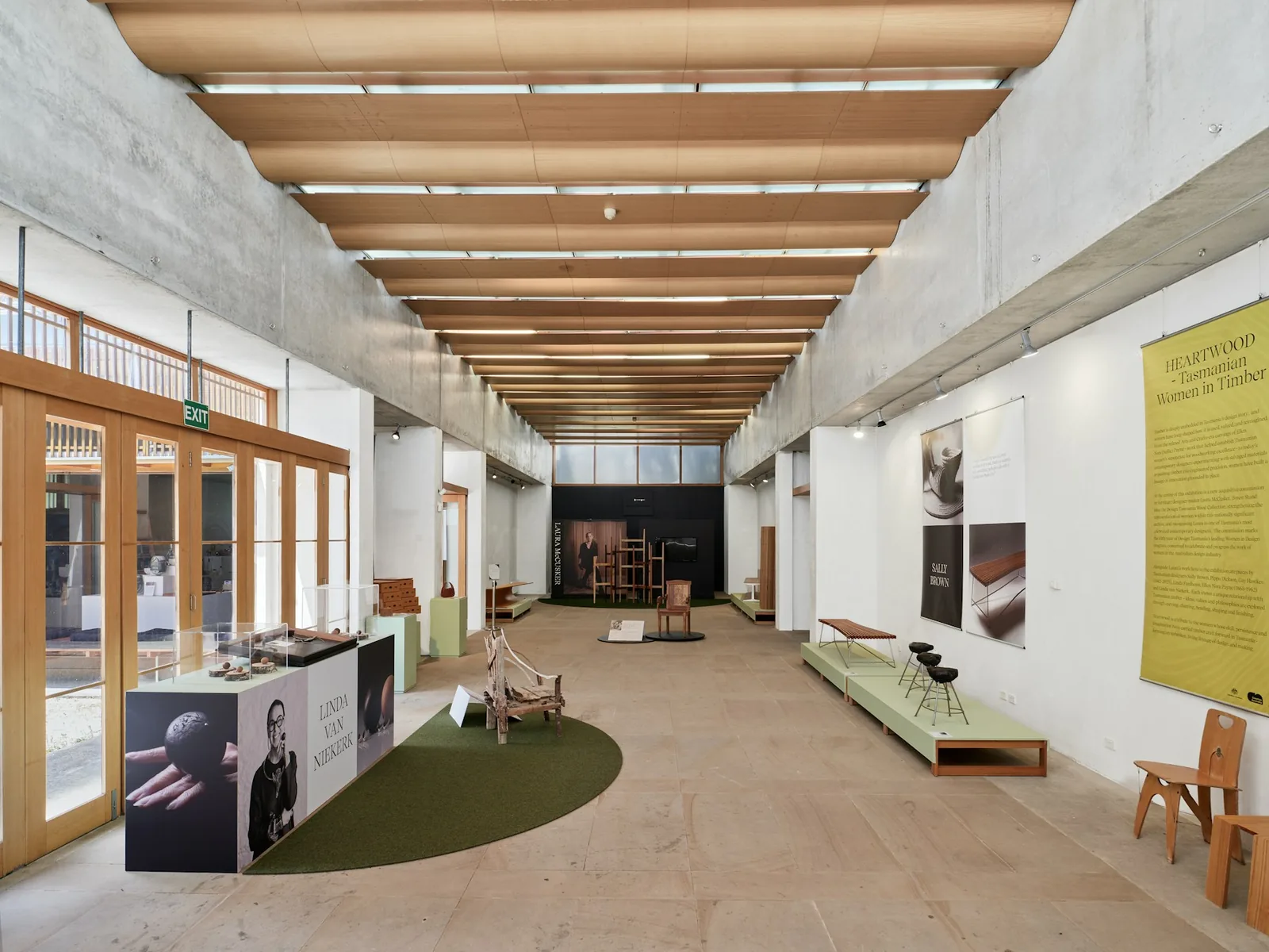 Heller moderner Museumsraum mit Vitrinen, Ausstellungsobjekten und Informationstafeln